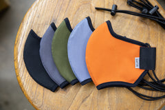 flat shot of the organic summer cotton masks in black, dark grey, olive, cool river, and burnt orange