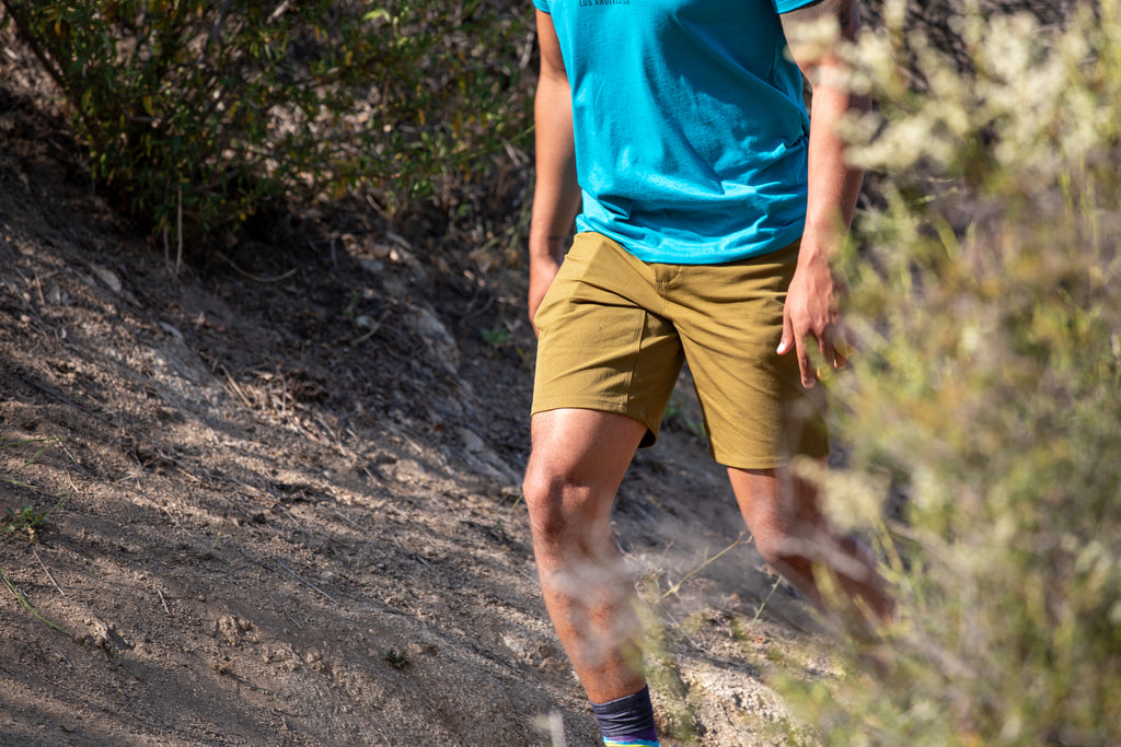 A model is wearing the durable cotton trouser short in olive drab.