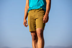 A model is wearing the durable cotton trouser short in olive drab.