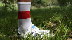 A model is wearing the volar active flag sock in ENG