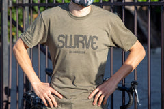 A model in USA super soft tri-blend 1968 swrve logo t-shirt in heather pine.